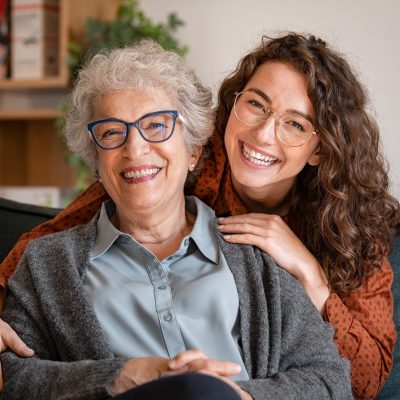 Happy grandmother with smiling granddaughter at home